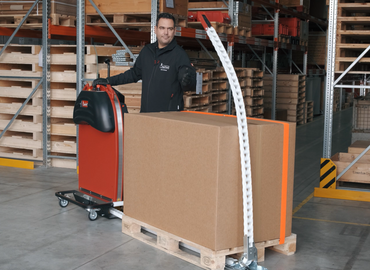 User catches red head piece of the mobile, ergonomic ErgoPack pallet strapping machine with reusable straps