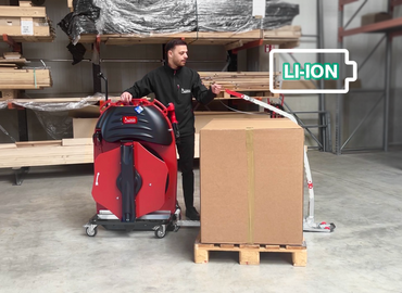 ErgoPack machine trainee training user in front of Euro pallet and packaged goods with ErgoPack Lithium machine chain and red head piece